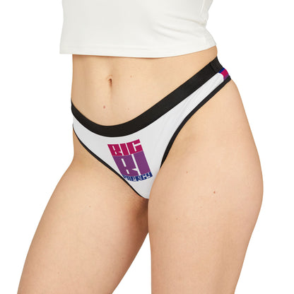 A pair of the BIG BI ENERGY g-string thong from Printify, made with breathable antimicrobial fabric featuring white material and black trim. The front showcases a bold, multicolored design that reads "BIG BI ENERGY" in uppercase letters, with "BIG" in pink and "ENERGY" in blue, incorporating the bisexual pride flag colors.