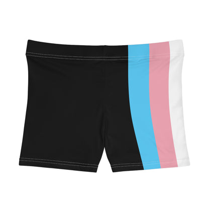 A person wearing Printify's Transgender Pride Flag Short Shorts, which feature the horizontal stripes of light blue, pink, white, pink, and light blue from the transgender pride flag. Made from a moisture-wicking polyester spandex blend, these high-waisted shorts reveal the person's bare midriff and upper thighs.