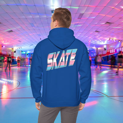 A man with light brown hair, wearing a black hoodie that features "SKATE" in large, colorful letters on the back, stands in a roller skating rink illuminated by vibrant lighting with people skating in the background. The high-quality SKATE Trans Flag Hoodie is made from ethically grown US cotton and is part of Printify's unisex heavy blend collection. Available for Australian shipping.