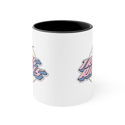 The Trans Rights colorful accent mug by Printify showcases a white coffee mug with a pink handle and vibrant interior, featuring the bold, retro-style text "TRANS RIGHTS" against a circular, off-white background. Above the text is a stylized star with dynamic lines that reflect the colors of the transgender pride flag, creating an energetic sense of movement.