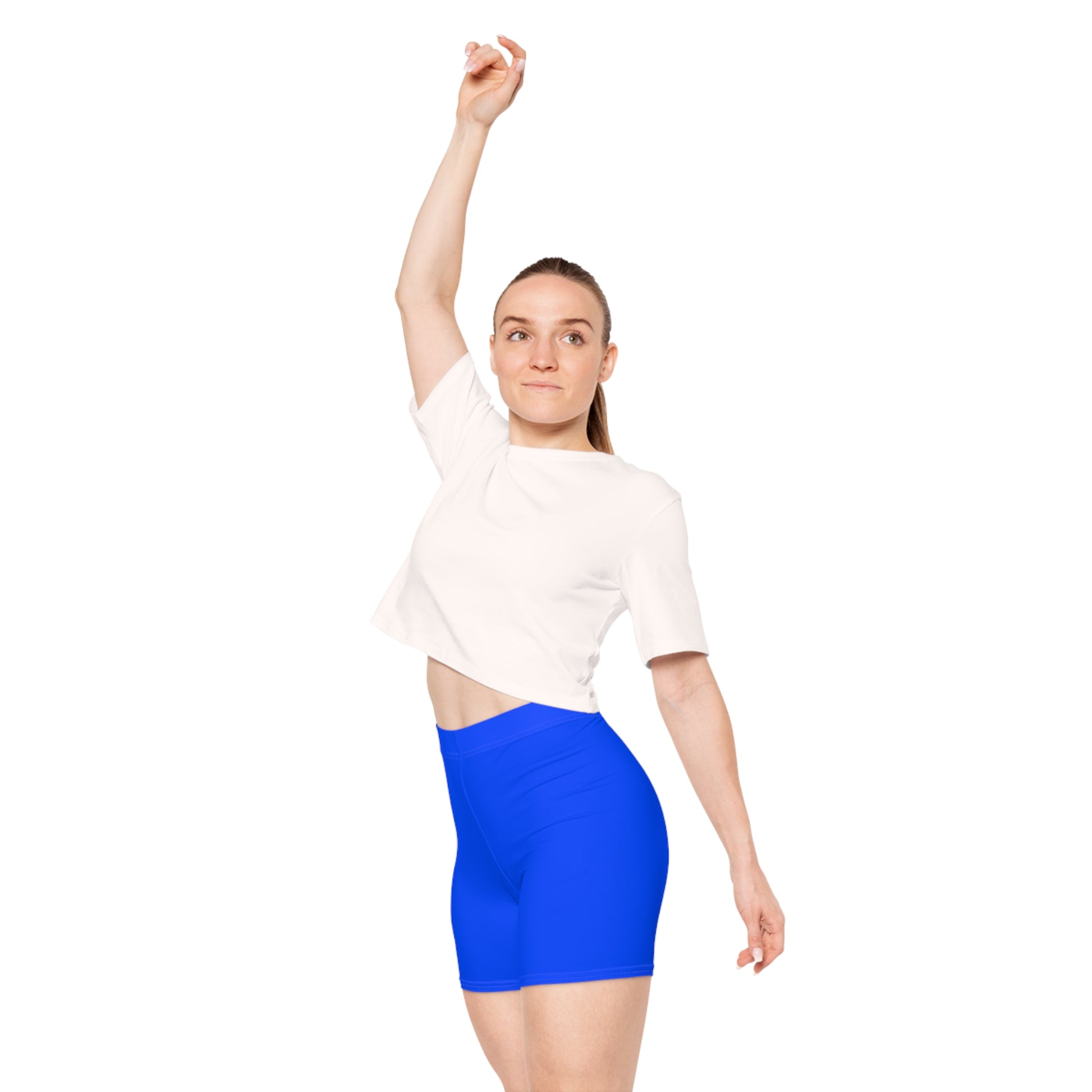 The image showcases a person from the side wearing Printify's Progress Pride Rainbow Flag and Blue Bike Shorts, which feature a vibrant rainbow design incorporating the Pride flag colors, transgender flag hues, and brown and black stripes at the top to symbolize inclusivity.