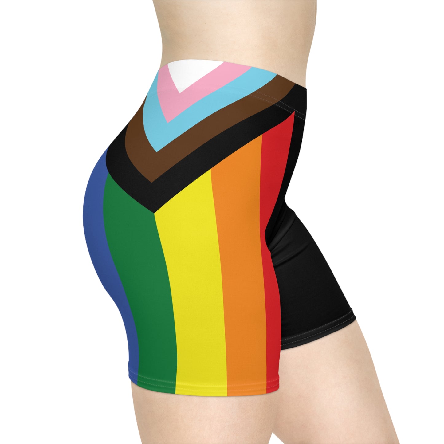 A person is wearing Progress Pride Bike Shorts by Printify, which feature a colorful design with a rainbow pride flag incorporating stripes for people of color and the transgender community. These moisture-wicking shorts fit closely to the body.