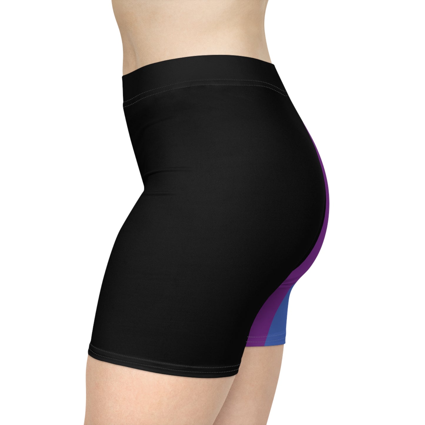 A person is wearing Progress Pride Bike Shorts by Printify, which feature a colorful design with a rainbow pride flag incorporating stripes for people of color and the transgender community. These moisture-wicking shorts fit closely to the body.