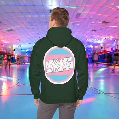 A person wearing a Printify SKATE Trans Flag round logo Hoodie, featuring the word "SKATE" inside a blue and pink circular graphic, stands at the center of a colorful roller skating rink with vibrant lights and other skaters in the background.