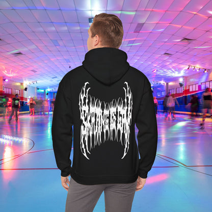 A person wearing the "SKATING IS GAY but make it death metal" hoodie stands in a brightly lit roller skating rink. The rink is adorned with colorful lights, and other people are skating in the background.