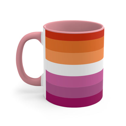 The Lesbian pride flag colorful accent mug by Printify features a vibrant design with horizontal stripes in varying shades of orange, pink, and purple. It has a red handle and colorful interior that create an eye-catching contrast against the plain white background.