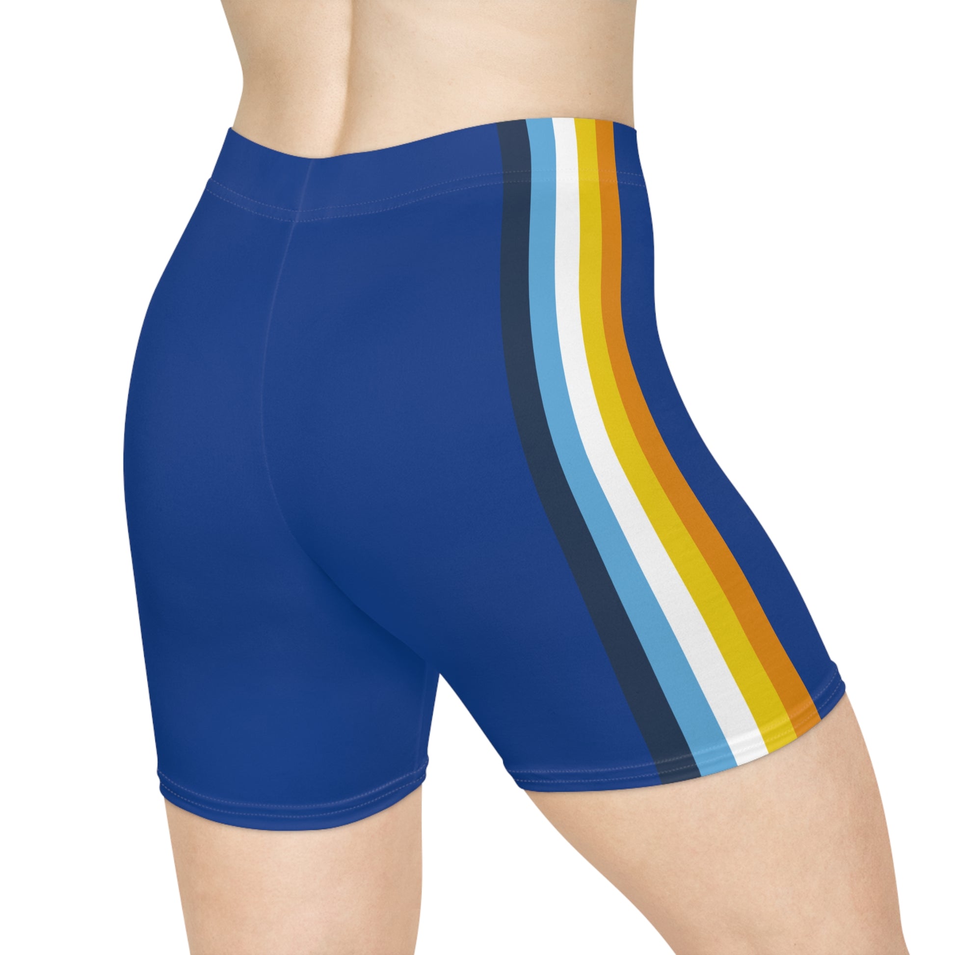 A person wearing Printify's Aroace Pride Flag Bike Shorts, which are high-waisted blue athletic shorts featuring vertical stripes in dark blue, light blue, white, yellow, and orange down the side. The photo captures the lower torso and upper thighs from a side view.