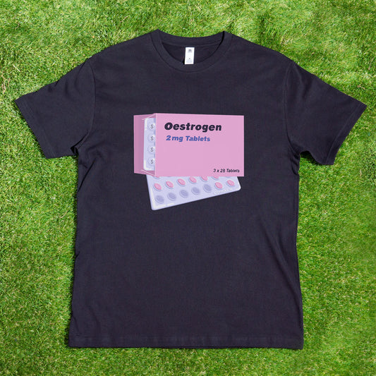 On the grass, an Estrogen tablets T-shirt from My Store is displayed, highlighting a trans pride design with an open pink box labeled "Oestrogen 2 mg Tablets" and a visible blister pack, celebrating Estrogen HRT in style.