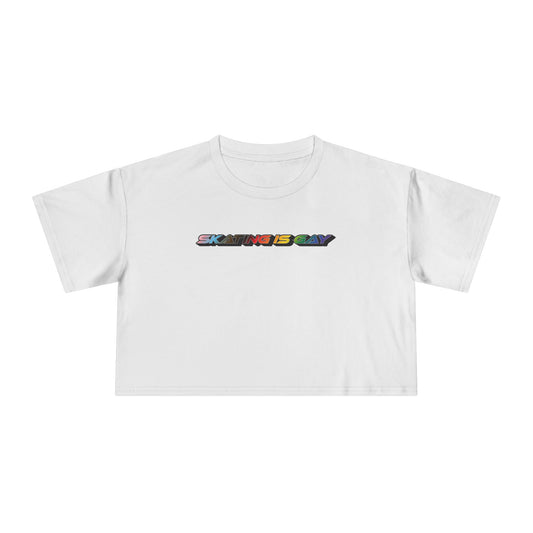 A locally printed crop tee by Gay Skate, featuring short sleeves and a bold "SKATING IS GAY" slogan in rainbow gradient letters across the chest, perfect for celebrating queer skate culture.