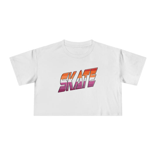 Gay Skate's SKATE lesbian pride flag - locally printed crop tee is a white cropped shirt featuring the word "SKATE" in bold, gradient letters transitioning from orange to pink. The retro, 3D-style lettering adds a distinct flair to this queer skate streetwear piece, which also includes short sleeves and a round neckline.