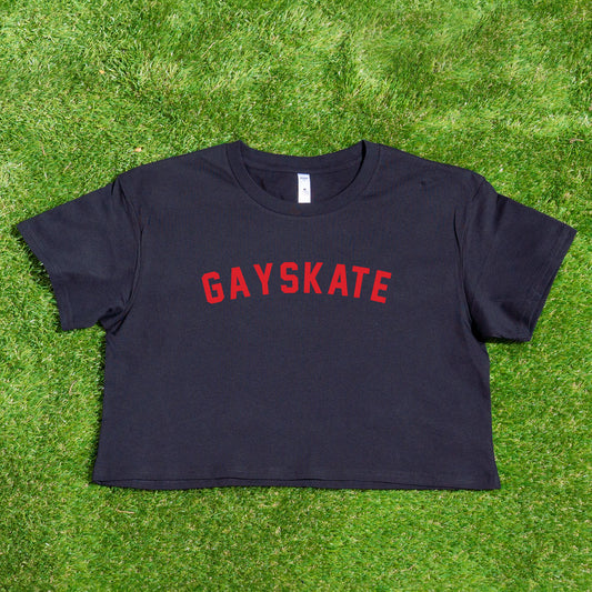 A crop top featuring the "GAY SKATE" retro 1982 red logo, printed locally, displayed on green grass.