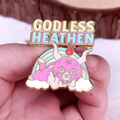 Rainbow, pink and gold enamel Pin with 'Godless Heathen' text and devil creature