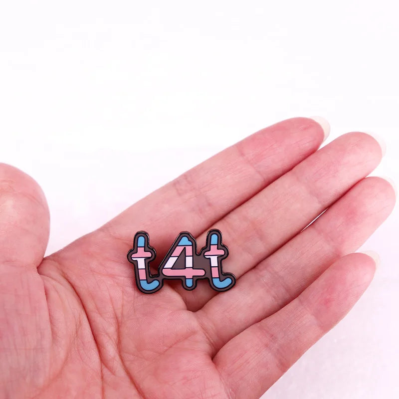 The Gay Skate Transgender T4T LGBTQ+ Enamel Pin proudly displays the term "t4t" with each letter and number filled in with the colors of the transgender pride flag: light blue, pink, and white. This stylish pin is a perfect accessory for showing solidarity and pride.