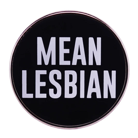 A stylish pin from Gay Skate, the MEAN LESBIAN Pin showcases a sleek black enamel design with bold white text that reads "MEAN LESBIAN.