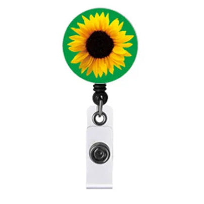 A retractable badge reel with Invisible Disability sunflower design on a green background, attached to a white clip on a plain white background.
