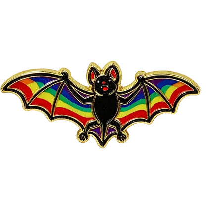 A bat-shaped enamel pin with rainbow-coloured wings and a black body