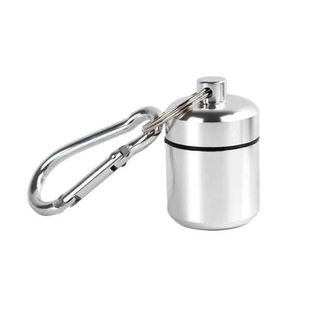 A small cylindrical silver metal container attached to a silver carabiner for storing pills and other small items. Waterproof