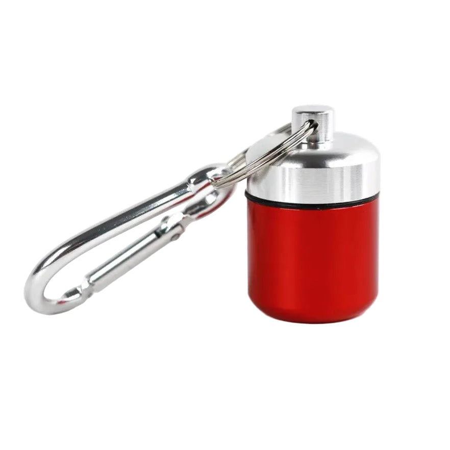 A small cylindrical red metal container with a silver lid attached silver carabiner for waterproof medicine storage