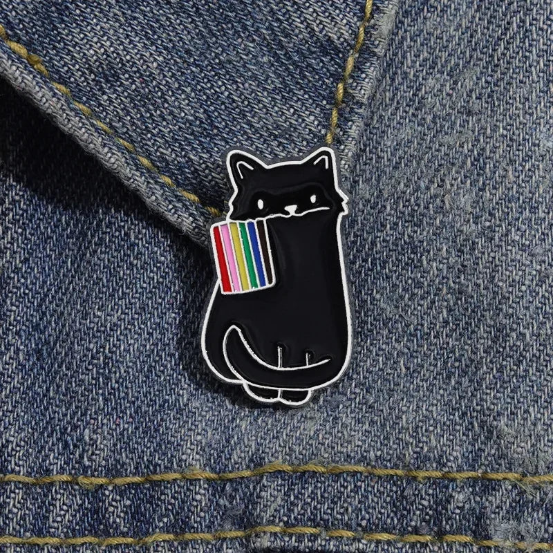 Black cat pin with rainbow flag on denim fabric