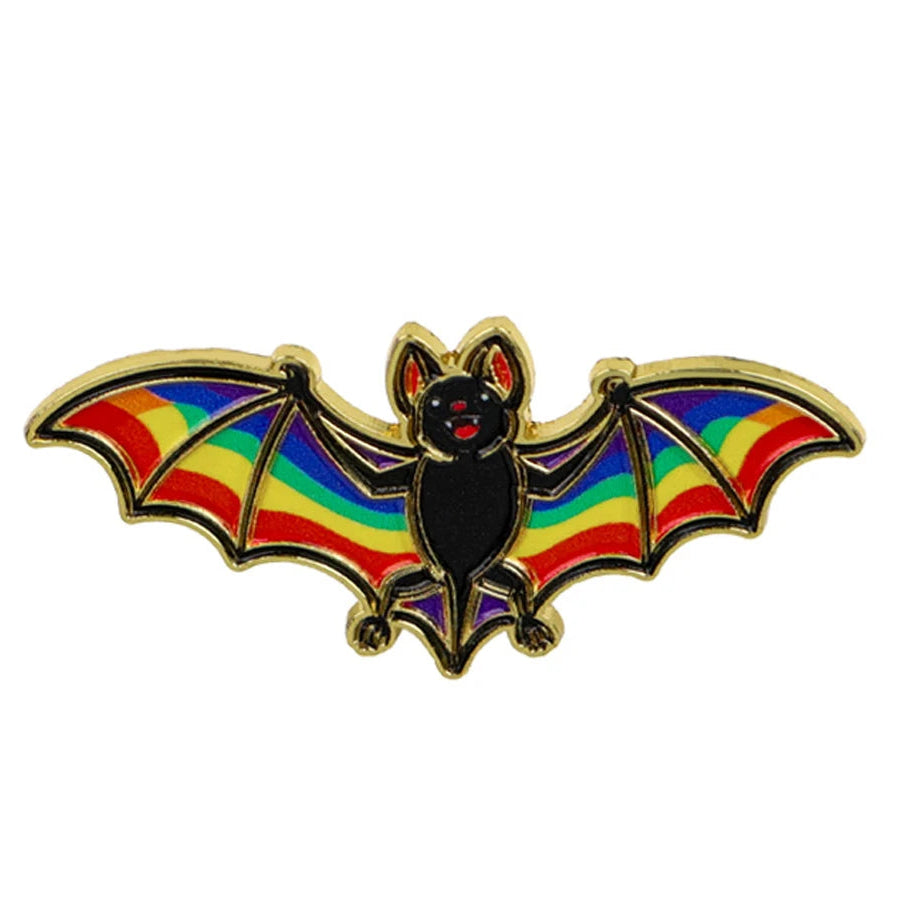 A bat-shaped enamel pin with rainbow pride flag wings and gold metal outlines
