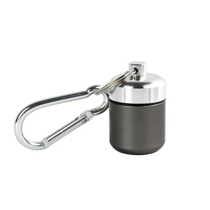 Dark grey medication storage container with silver lid. Waterproof aluminium pill storage cylinder with silver carabiner