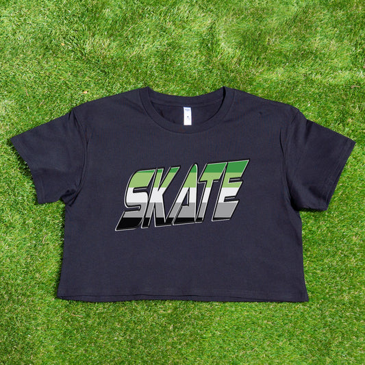 Featured against a vibrant background, the SKATE Aromantic pride flag crop tee by Gay Skate showcases "SKATE" in bold, green and white gray and black block letters on a black crop tee seamlessly blending the aro flag's colors.