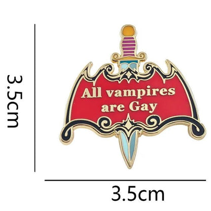 An enamel pin shaped like a dagger with a red shield and the text 'All vampires are Gay' in white, shown with  text indicating 3.5cm by 3.5cm