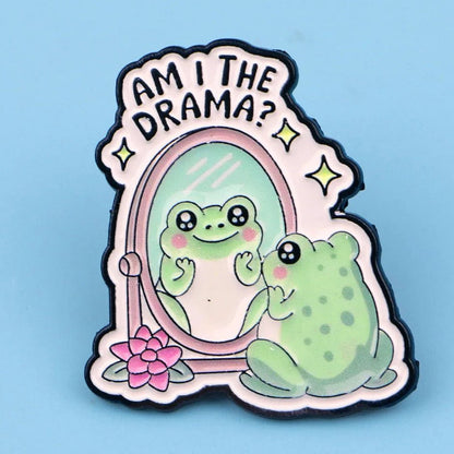 Badge with a cute cartoon frog looking into a mirror with 'Am I the drama?' text. Drag queen meme