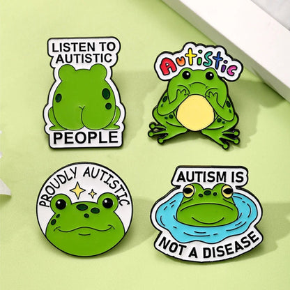 Four green frog-themed pins with autism awareness messages 