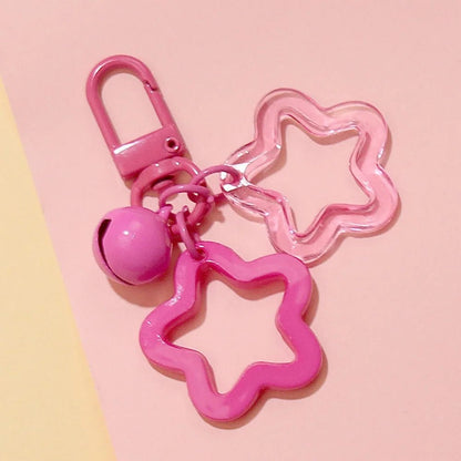 Pink star-shaped keychain with a bell on a pink background