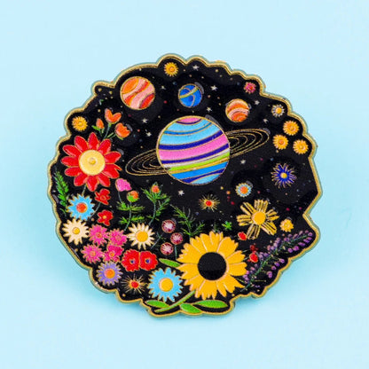 Beautiful pin with rainbow pride space-themed design featuring planets and flowers