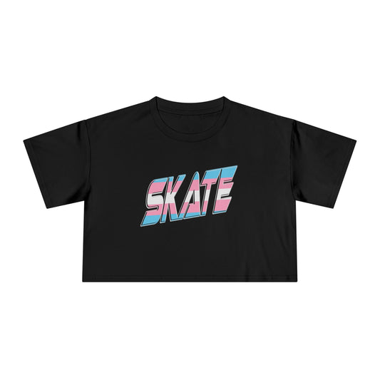 The "SKATE Trans Flag - locally printed crop tee" by Gay Skate is a black T-shirt featuring the word "SKATE" in bold, colorful, and stylized letters on the front. The letters have a gradient effect with shades of pink, blue, and white reminiscent of the transgender flag, giving the design a vibrant and dynamic appearance. The T-shirt has a cropped fit perfect for streetwear fashion.