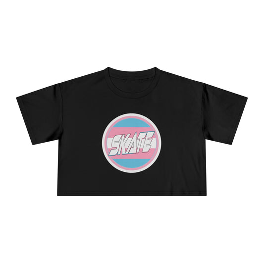 The SKATE Trans Flag round logo - locally printed crop tee by Gay Skate is a black cropped shirt that showcases a round emblem in the center, featuring the word "SKATE" in white stylized text. The emblem is bordered in blue and pink stripes, reminiscent of the trans flag logo, making it a standout piece of queer skatewear.