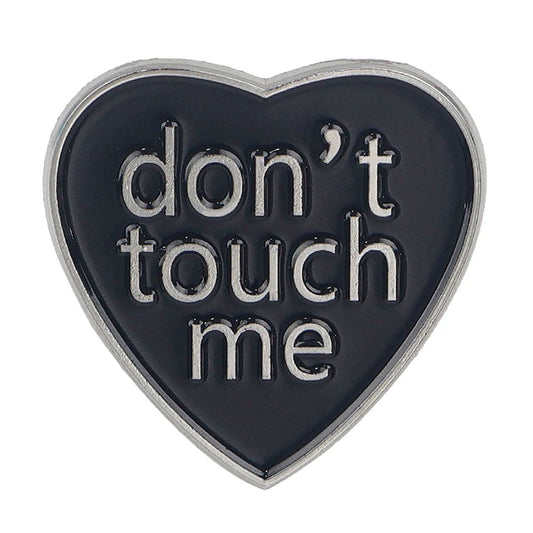 Heart-shaped metal badge with 'don't touch me' text