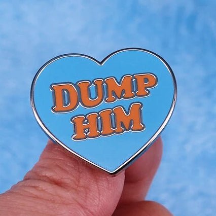 Heart-shaped pin with 'Dump Him' text in red 