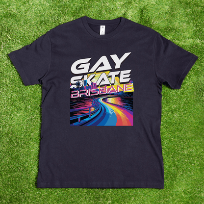 A black "Gay Skate Brisbane River" T-shirt from My Store lies on grass, showcasing the vibrant words "GAY SKATE BRISBANE" in bold, multi-colored letters. The hand-printed T-shirt design features a skater gliding along a rainbow-colored path against a dark background, celebrating diversity.