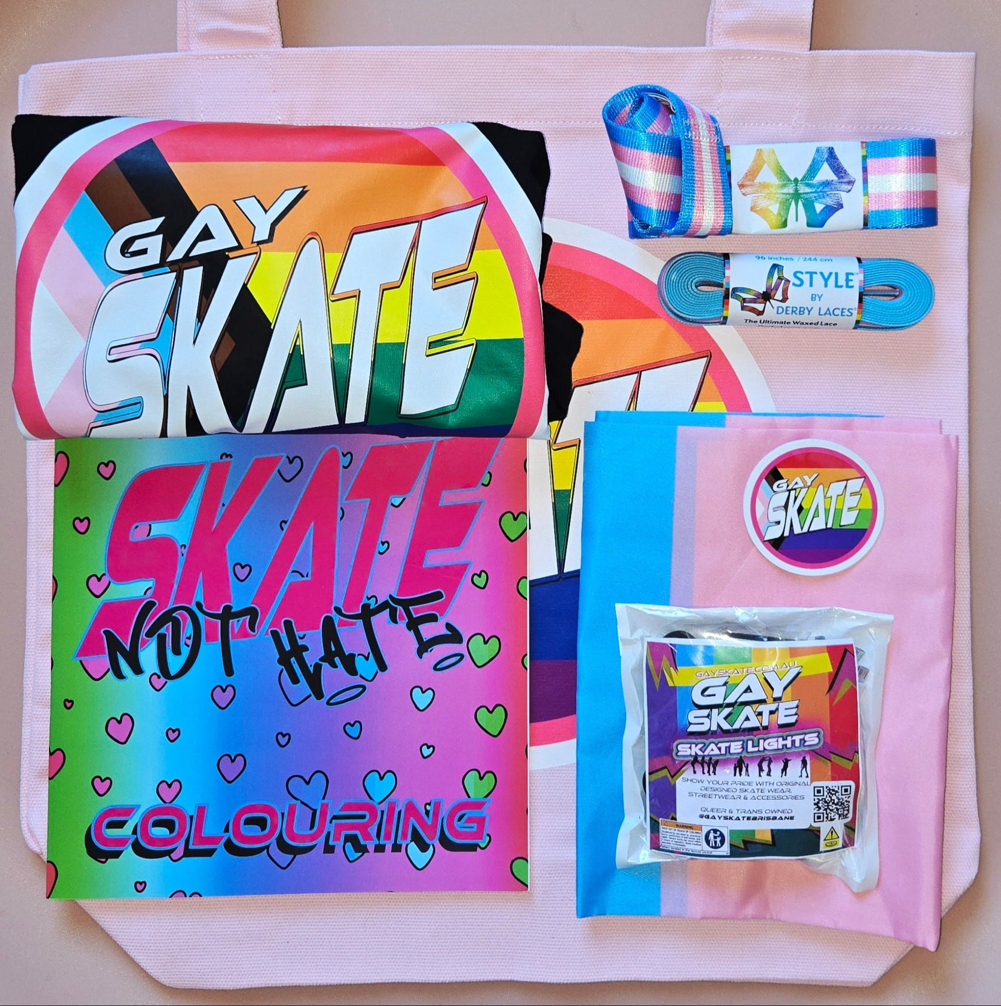 Collection of Gay Skate products including a tote bag, coloring book, skate lights, laces, tee, gear leash, pride flag and stickers