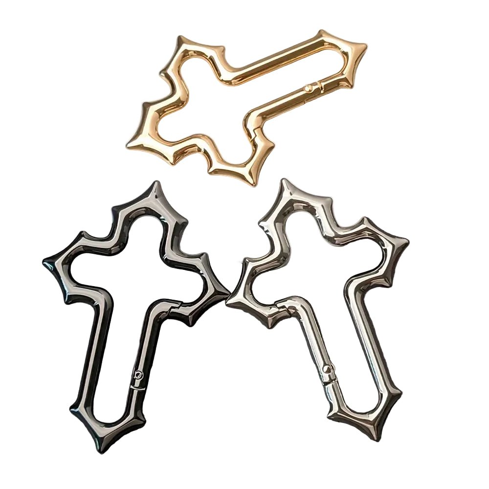 Gold, black and silver Gothic cross carabiner keychains arranged on a white background.
