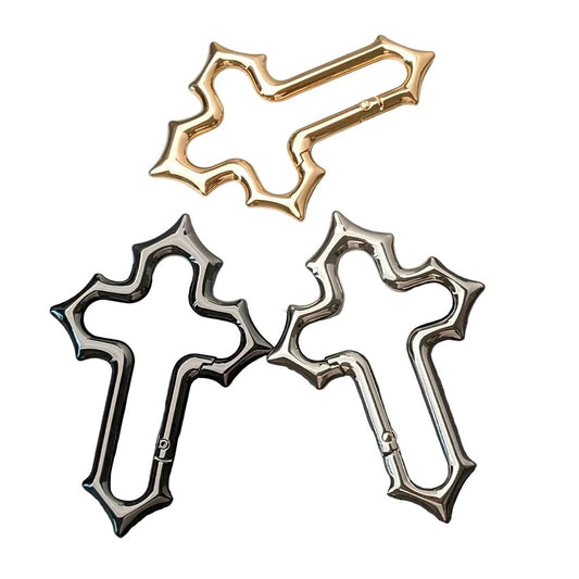 Gold, black and silver Gothic cross carabiner keychains arranged on a white background.
