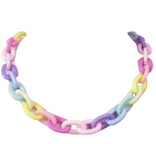 A Harajuku Candy Colour Resin Choker Chain by Gay Skate is showcased on a display bust against a purple background decorated with small star shapes. The choker features chunky chain links in candy-colored, pastel shades of pink, blue, green, and yellow.