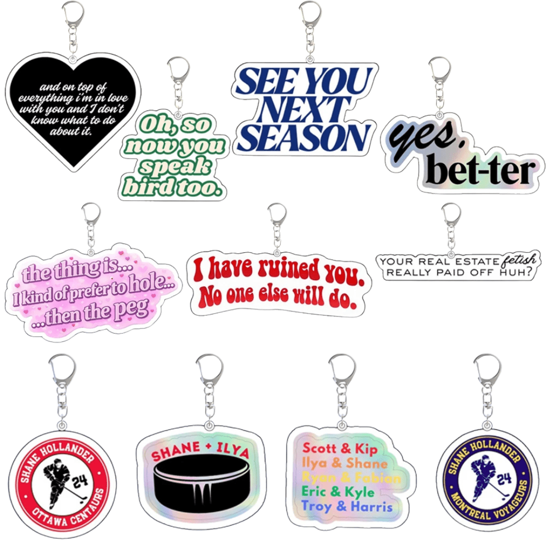 Heated Rivalry - Acrylic Keychains: A set of ten colorful keychains with fun phrases like “SEE YOU NEXT SEASON,” “yes, bet-ter,” hockey references, and circular designs featuring names.
