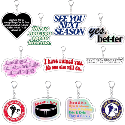 Heated Rivalry - Acrylic Keychains: A set of ten colorful keychains with fun phrases like “SEE YOU NEXT SEASON,” “yes, bet-ter,” hockey references, and circular designs featuring names.