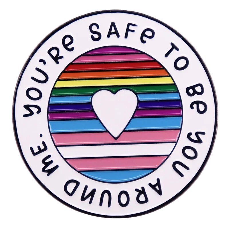 Round badge with rainbow flag and heart design and text 'You're safe to be you around me' on a white background