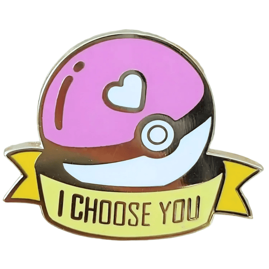 The I Choose You poke ball - pink enamel pin features a pink and white Poké Ball with a heart symbol, plus a yellow banner below that says "I CHOOSE YOU" in gold letters.