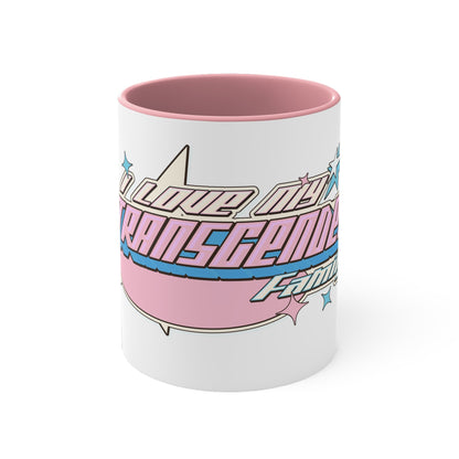 The "I Love My Transgender Family" original design accent mug by Printify features a white exterior with a vibrant, colorful interior. The retro-styled text reads "I Love My Transgender Family" in pink, blue, and cream colors accented by stars. This eye-catching design contrasts beautifully and evokes a nostalgic, vintage feel with its bold, decorative lettering.