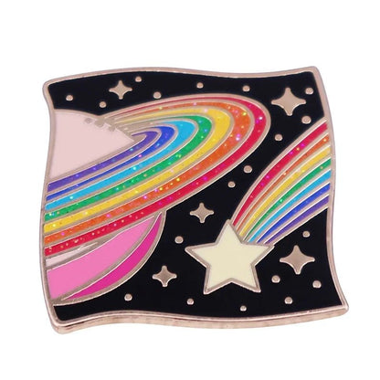 The Kiss Me Later enamel pin features a rainbow-striped Saturn and comet on a starry black background. This wavy square brooch adds a whimsical cosmic touch to your fashion accessories for a standout lgbt gay pride look.