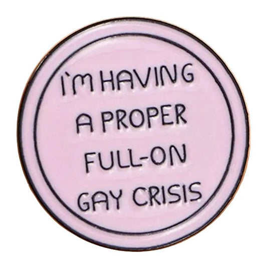 A round, light pink enamel pin titled "I'm Having A Proper Full-On Gay Crisis - Heated Rivalry," featuring the phrase "I'M HAVING A PROPER FULL-ON GAY CRISIS" in bold black capitals.