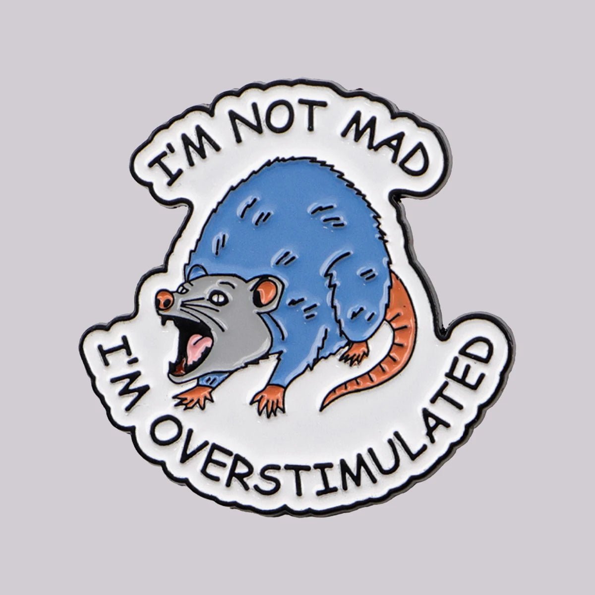 Enamel pin with a cartoon possum and text 'I'm not mad, I'm overstimulated' 