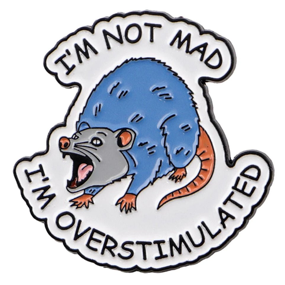 Enamel pin with a blue and gray possum illustration and text 'I'm not mad, I'm overstimulated' on a white background.