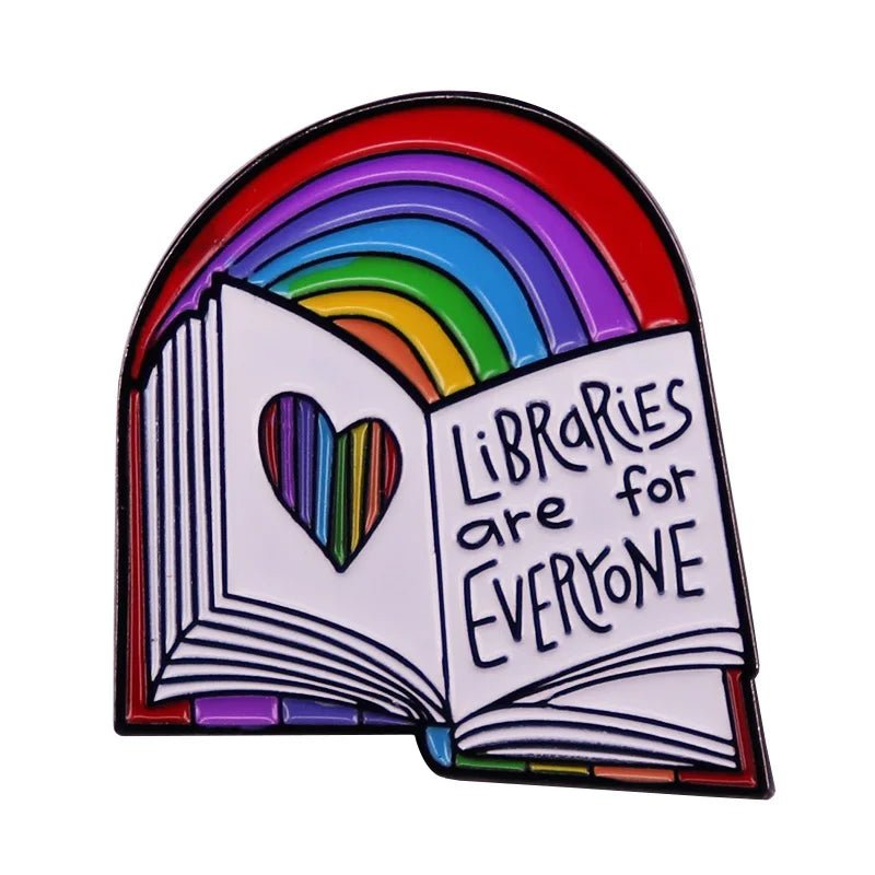 The Libraries Are For Everyone rainbow enamel pin features an open book with colorful arches above. The left page shows a rainbow heart cutout, and the right reads "Libraries Are For Everyone," symbolizing inclusivity and diversity in reading.